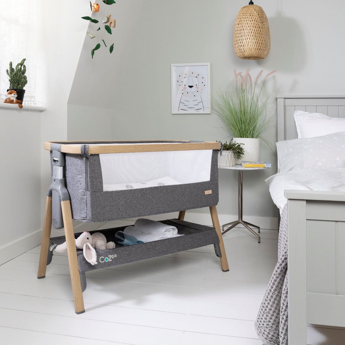 CoZee Bedside Crib in Oak and Charcoal with breathable mesh sides and drop-down panel
