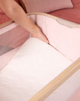 Lifestyle close-up showing the CoZee Air 2 bedside crib mattress being lifted out, demonstrating easy removal for cleaning and everyday care.