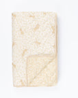 Cutout view of Love Cats cot bed coverlet showing reversible leopard and print design, with soft beige tones and piped edging