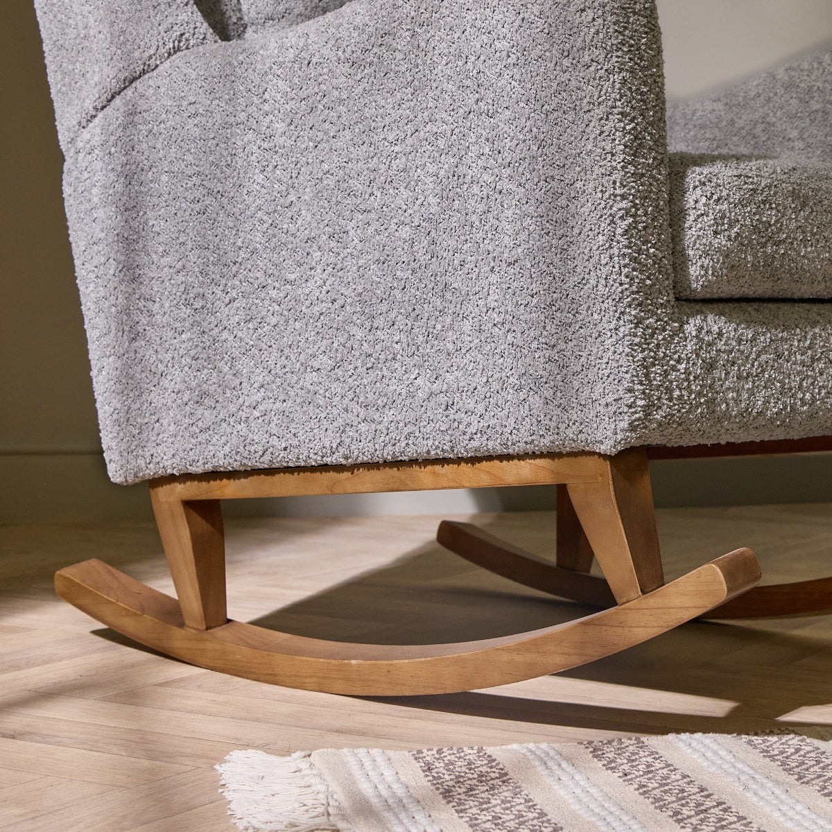 Close-up of the Harper Wingback rocking chair in cloud grey, highlighting the smooth wooden rocker for gentle gliding motion.