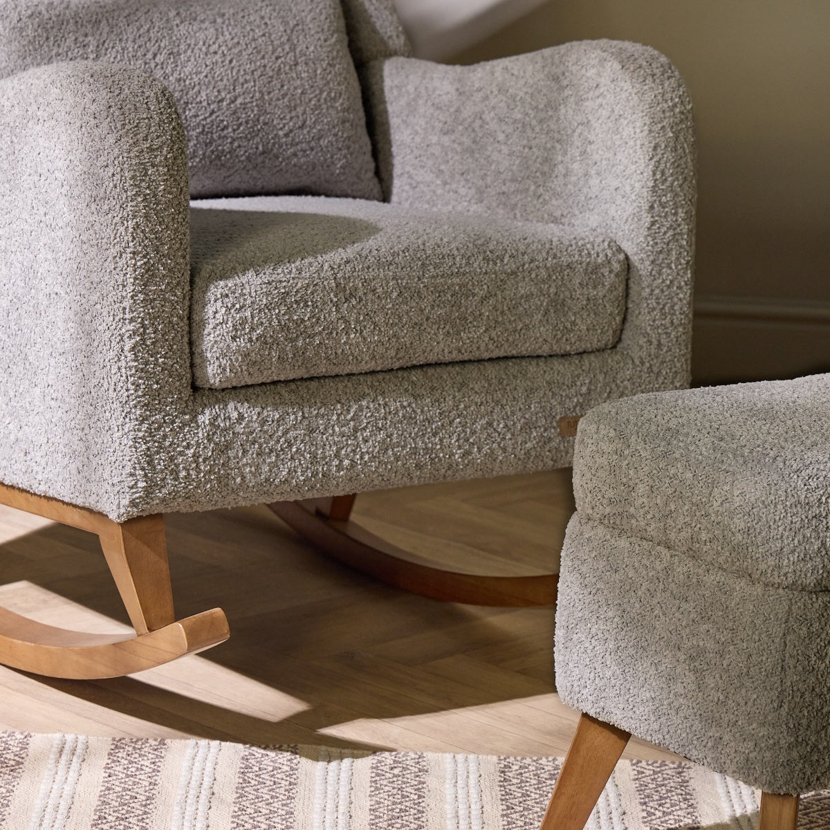 Close-up of Harper rocking chair and footstool in cloud grey, showing soft textured boucle fabric and gentle wood rocking base.