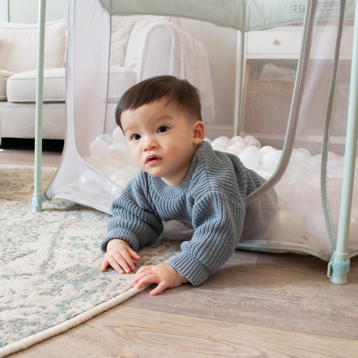 Child crawling out of the Hexa playpen in Leaf Terrazzo, highlighting safe zipped entry and soft cushioned floor for active play
