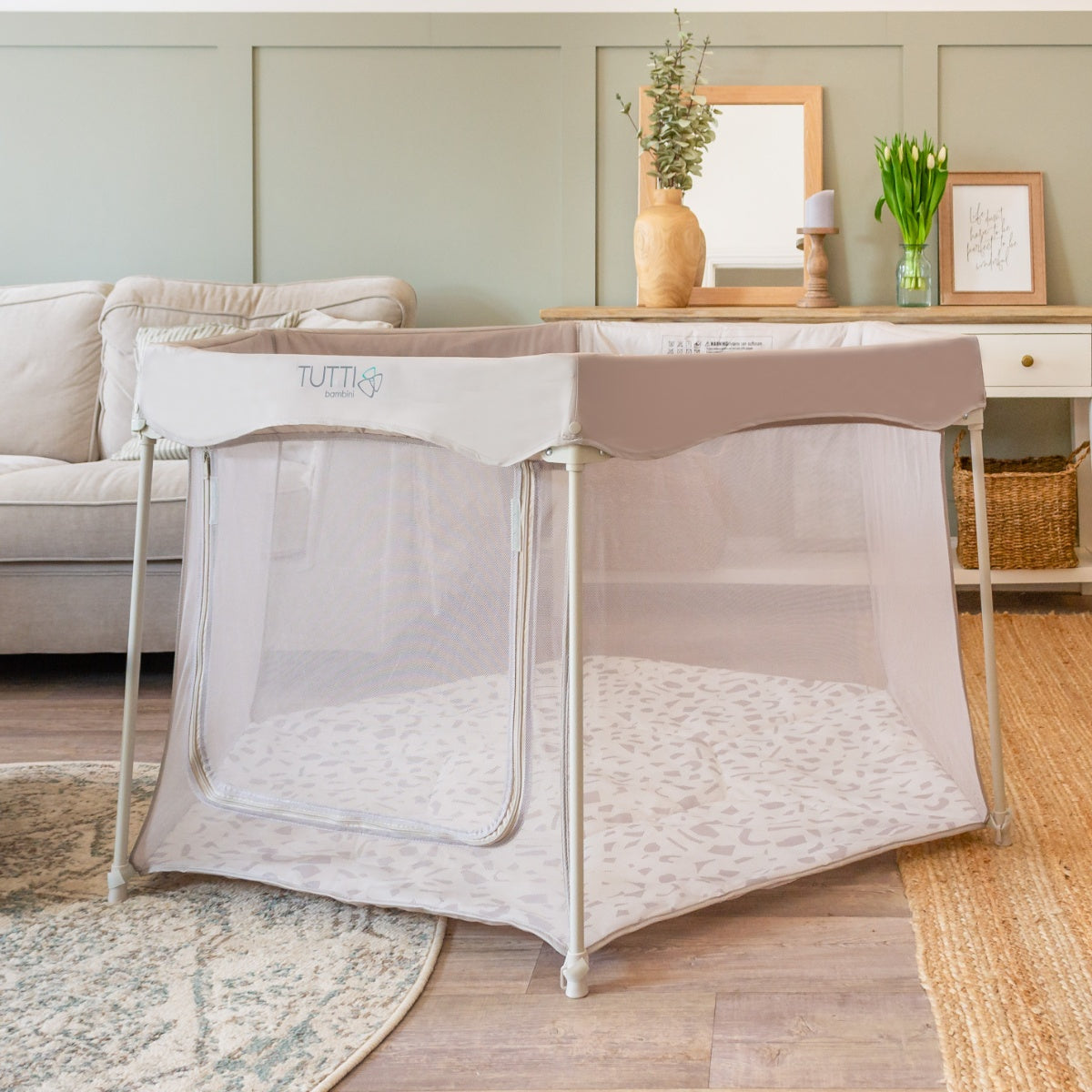 Full room view of the Hexa Playpen in mushroom terrazzo, with breathable mesh sides and zip-down opening in a calm neutral setting