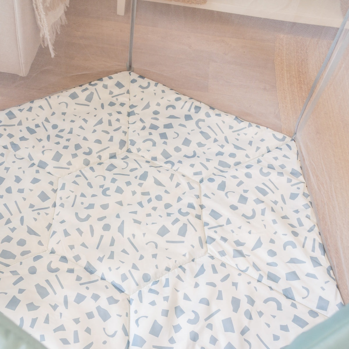 Overhead view of the Ocean Stone Terrazzo Hexa playpen showcasing the padded geometric-patterned floor mat in soft blue tones