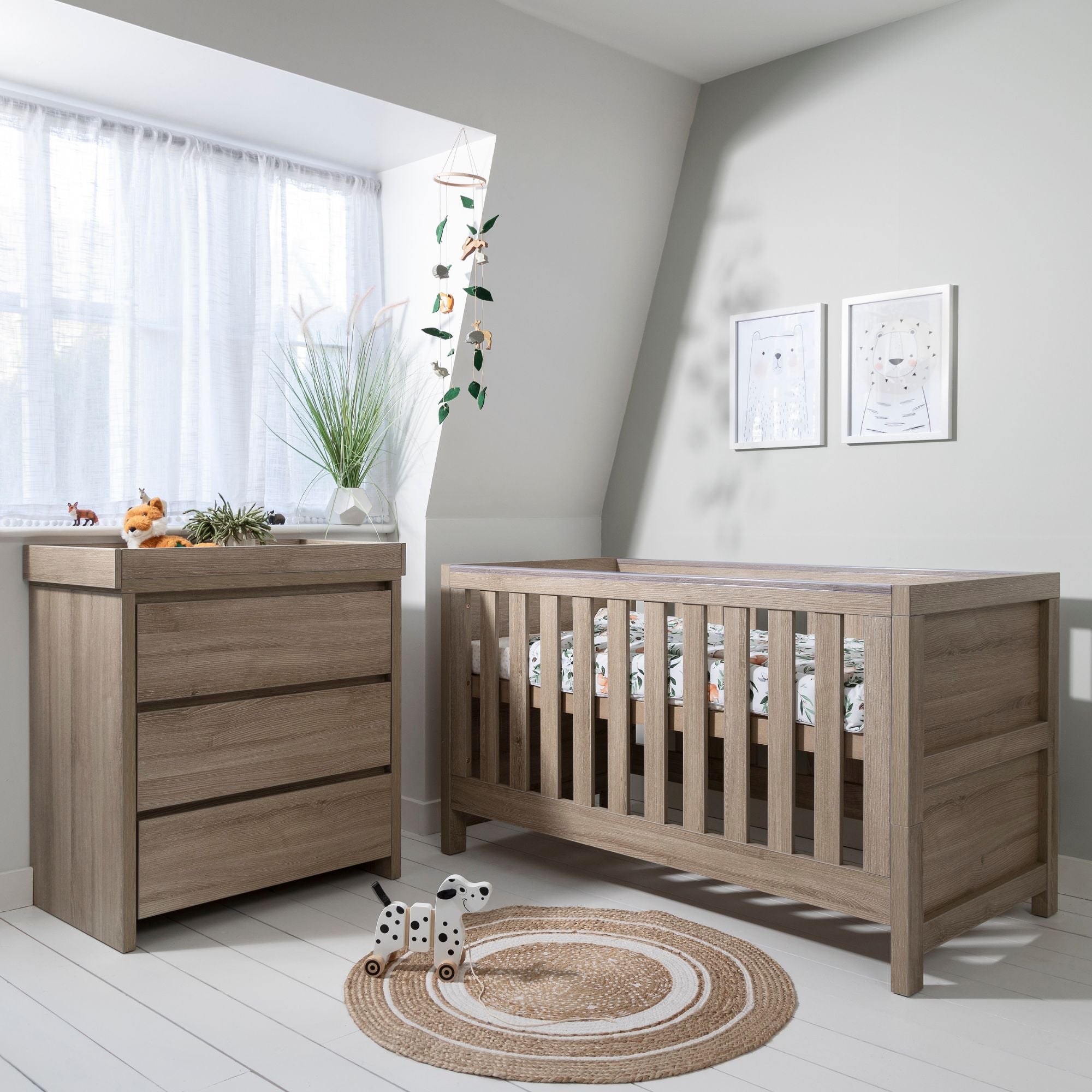 Modena 2-Piece Nursery Set in Oak shown in styled nursery setting, providing a cohesive and stylish solution with cot bed and changing unit for modern baby spaces.