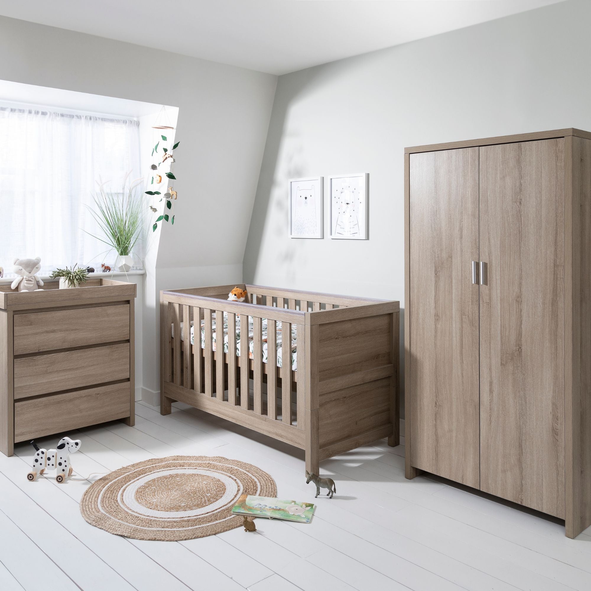 Modena 3-piece nursery set in oak shown in a styled room setting, displaying the cot bed, changing unit, and wardrobe, offering a warm and contemporary design ideal for a calming nursery environment.