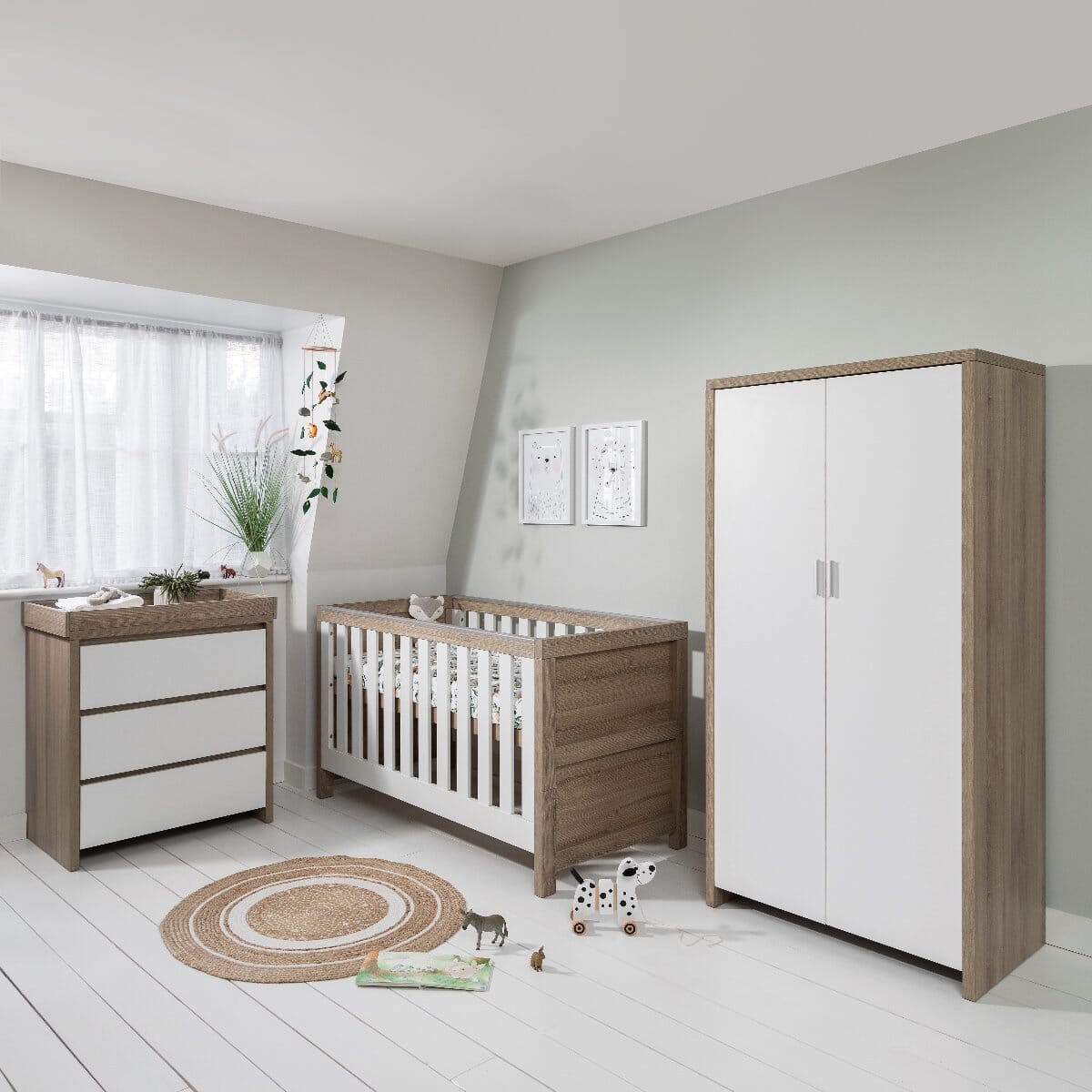 Modena 3 Piece Room Set in White and Oak and displayed in a nursery room setting, showcasing cot bed, chest changer, and wardrobe designed for a practical and stylish baby bedroom
