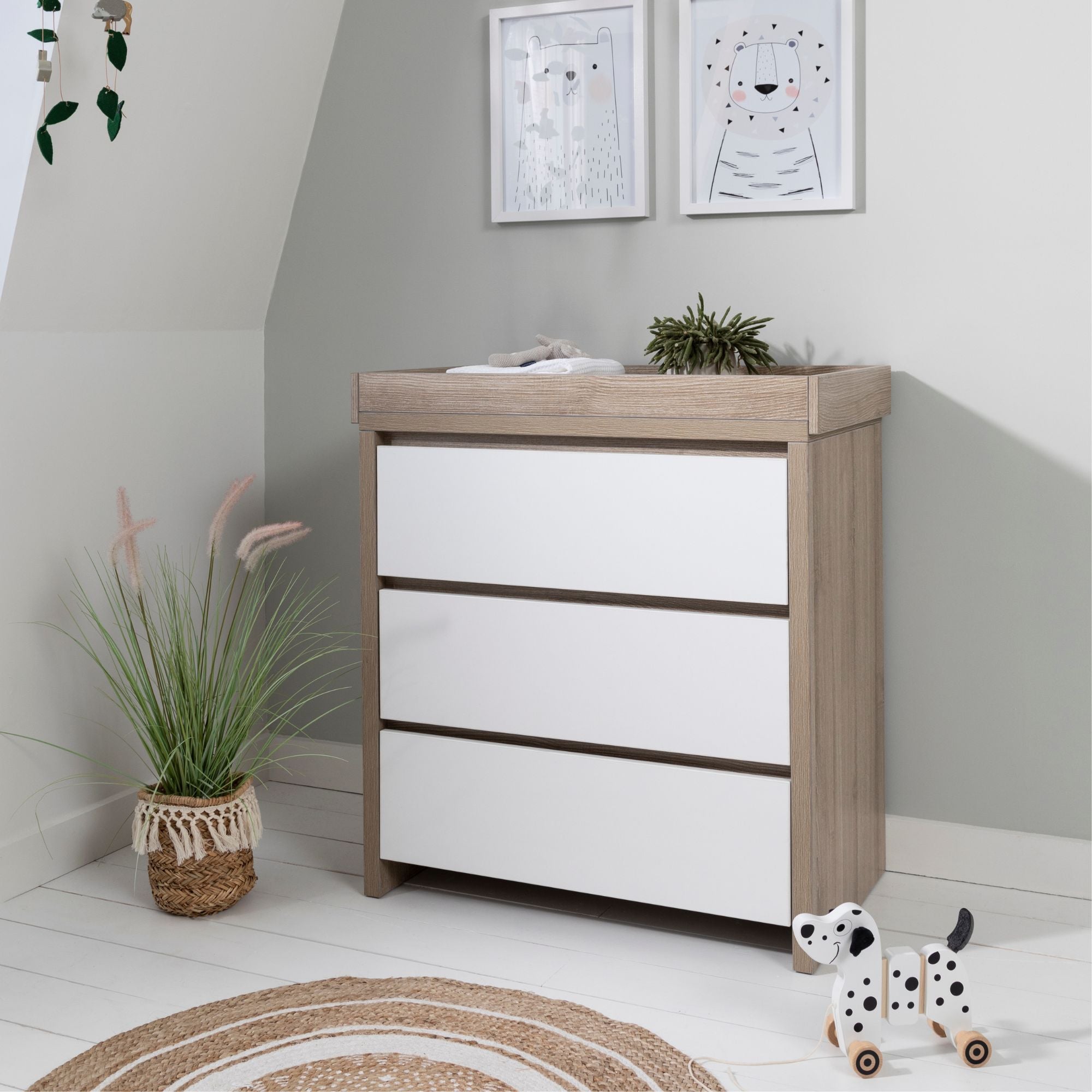 Modena Changing Unit White and Oak styled in a nursery setting, combining practical storage with contemporary style to organize baby essentials beautifully.