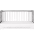 Modena Cot Bed in Grey Ash and White converted into a comfortable sofa bed, showcasing its space-saving functionality and modern design in a serene nursery setting