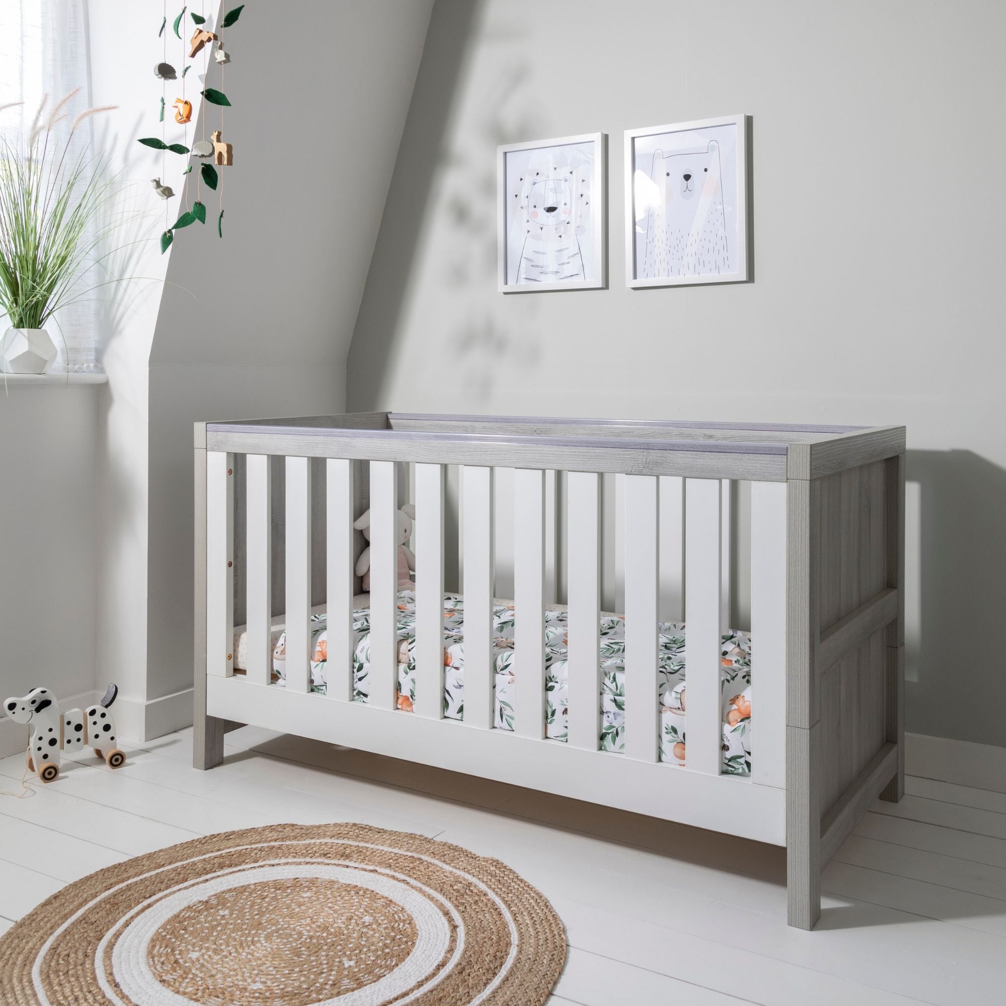 Modena Cot Bed in Grey Ash and White styled in a contemporary nursery, with woodland bedding and decorative accessories, ideal for versatile nursery themes