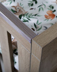 Close-up of the Modena Cot Bed in Oak highlighting the protective teething rail designed to prevent damage from teething babies.