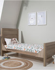 Modena Cot Bed in Oak converted into a toddler bed, creating a stylish and practical sleeping space for growing children.