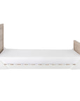 Side view of the Modena Cot Bed in White and Oak in toddler bed mode with the sides removed for easy access and independent sleeping.