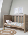Modena Cot Bed in Oak shown in sofa bed mode, ideal for toddlers transitioning from cot to bed, providing a comfortable seating or lounging option.