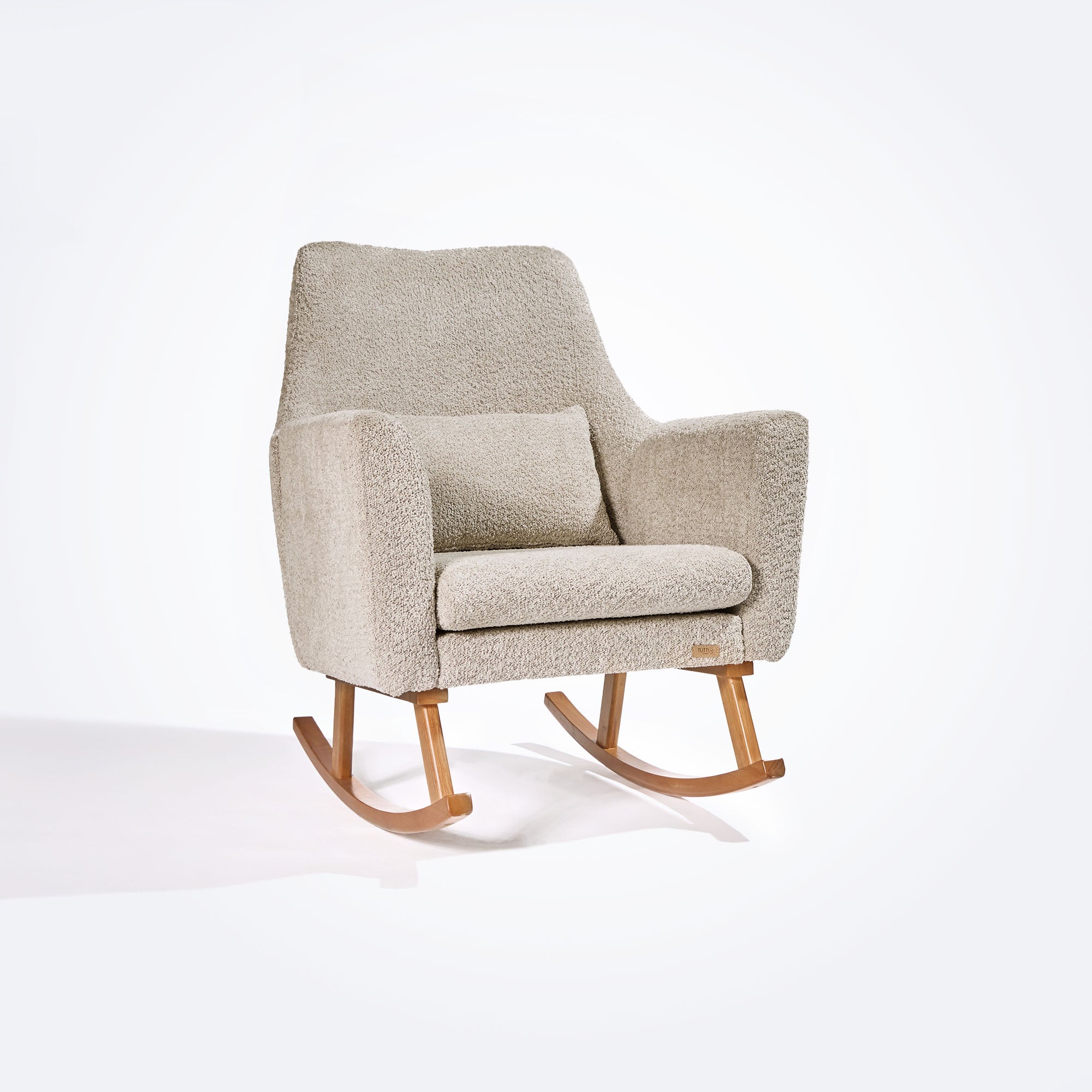 Angled cutout of the Oscar Luxe rocking chair in teddy mushroom, showing curved lines, high back and soft matching cushion