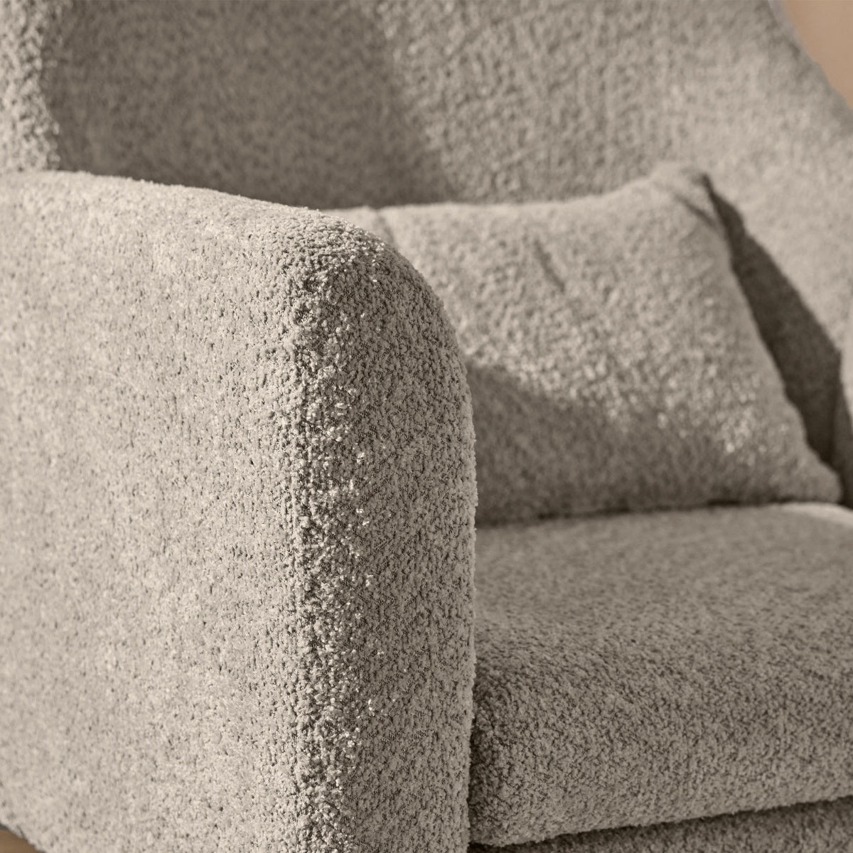 Close-up of the Oscar Luxe Rocking Chair in Teddy Mushroom showing the soft textured boucle fabric and matching lumbar cushion