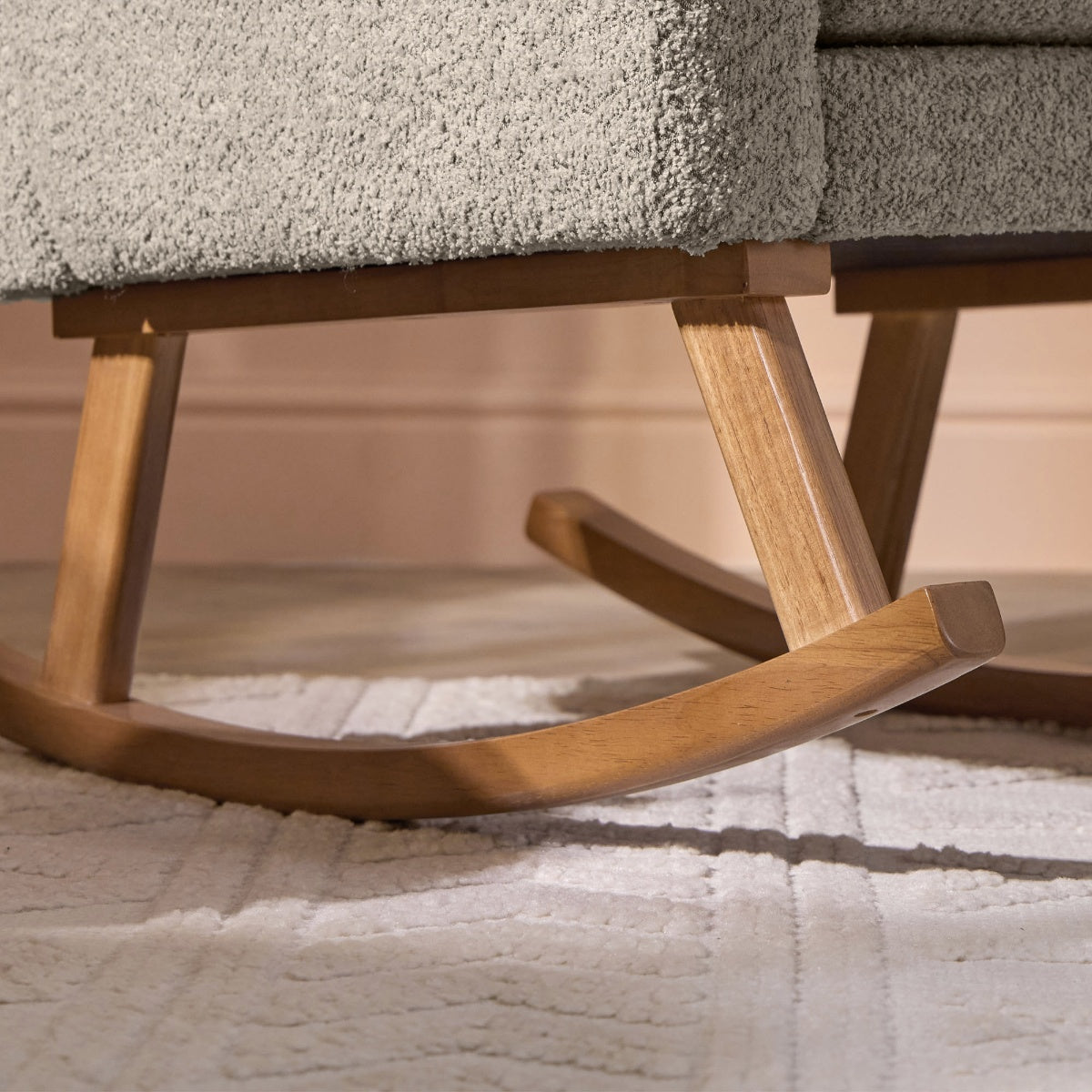 Close-up of the Oscar Luxe rockerโs solid oak curved base in mushroom finish, highlighting smooth wood grain and build quality