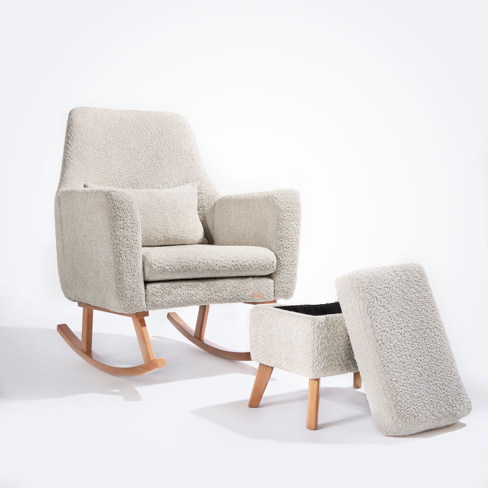 Cutout of the Oscar Luxe Rocking Chair and open footstool in boucle sage, with removable lid revealing hidden storage inside.