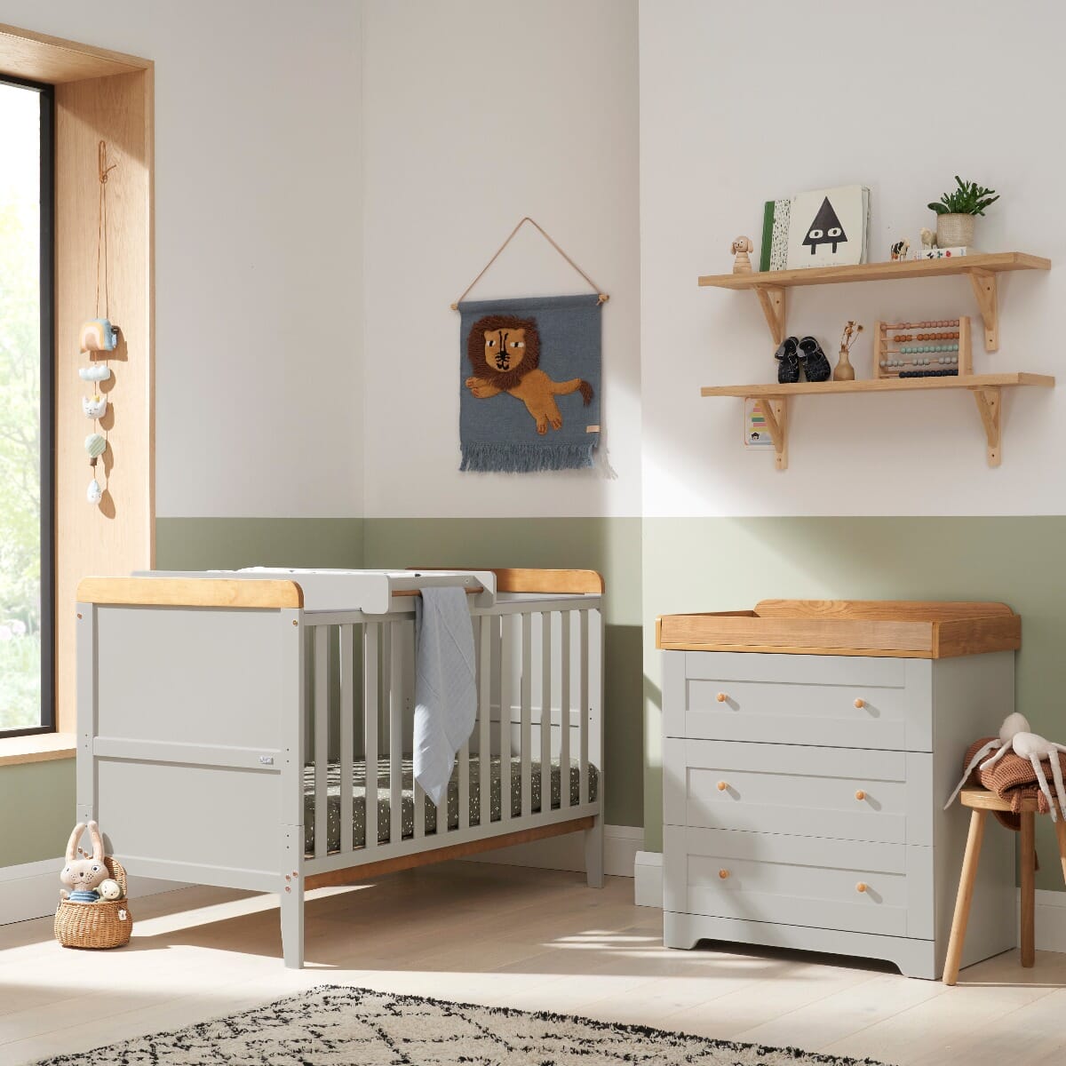 Nursery room setting featuring the Rio cot bed and chest changer in dove grey with honey oak details. The set combines modern simplicity with functionality, perfect for a stylish and practical baby room.