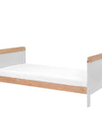 Front angle view of the Rio Cot Bed in Dove Grey/Oak converted into a toddler bed, showing solid wooden frame and low height suitable for children.