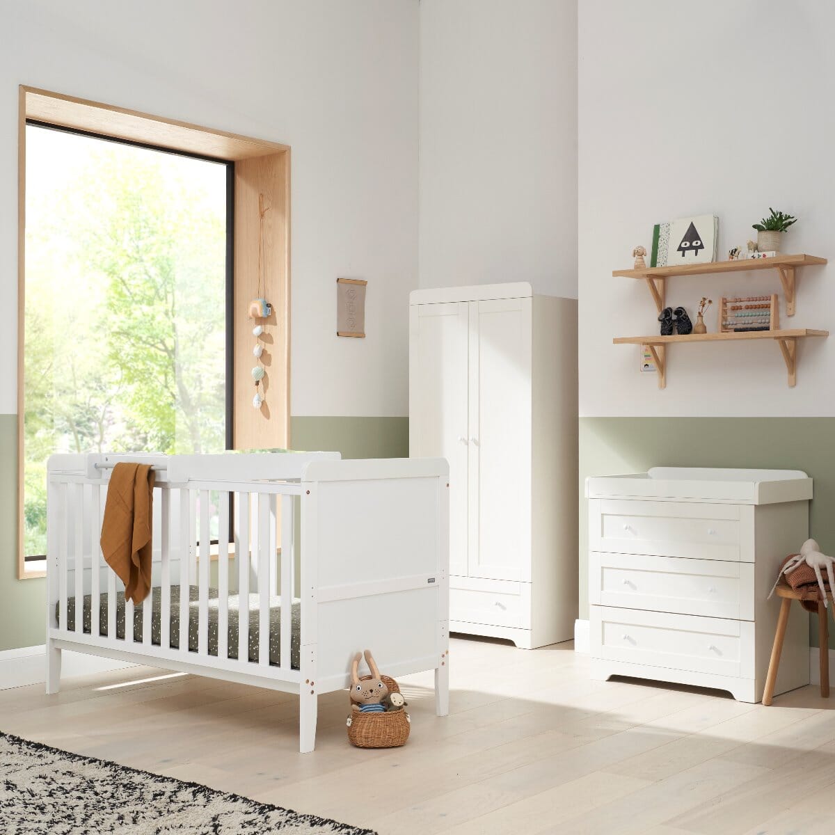 Rio three-piece nursery furniture set in white, including cot bed, wardrobe, and chest changer, styled in a modern nursery with soft green and white tones for a calming, functional space.