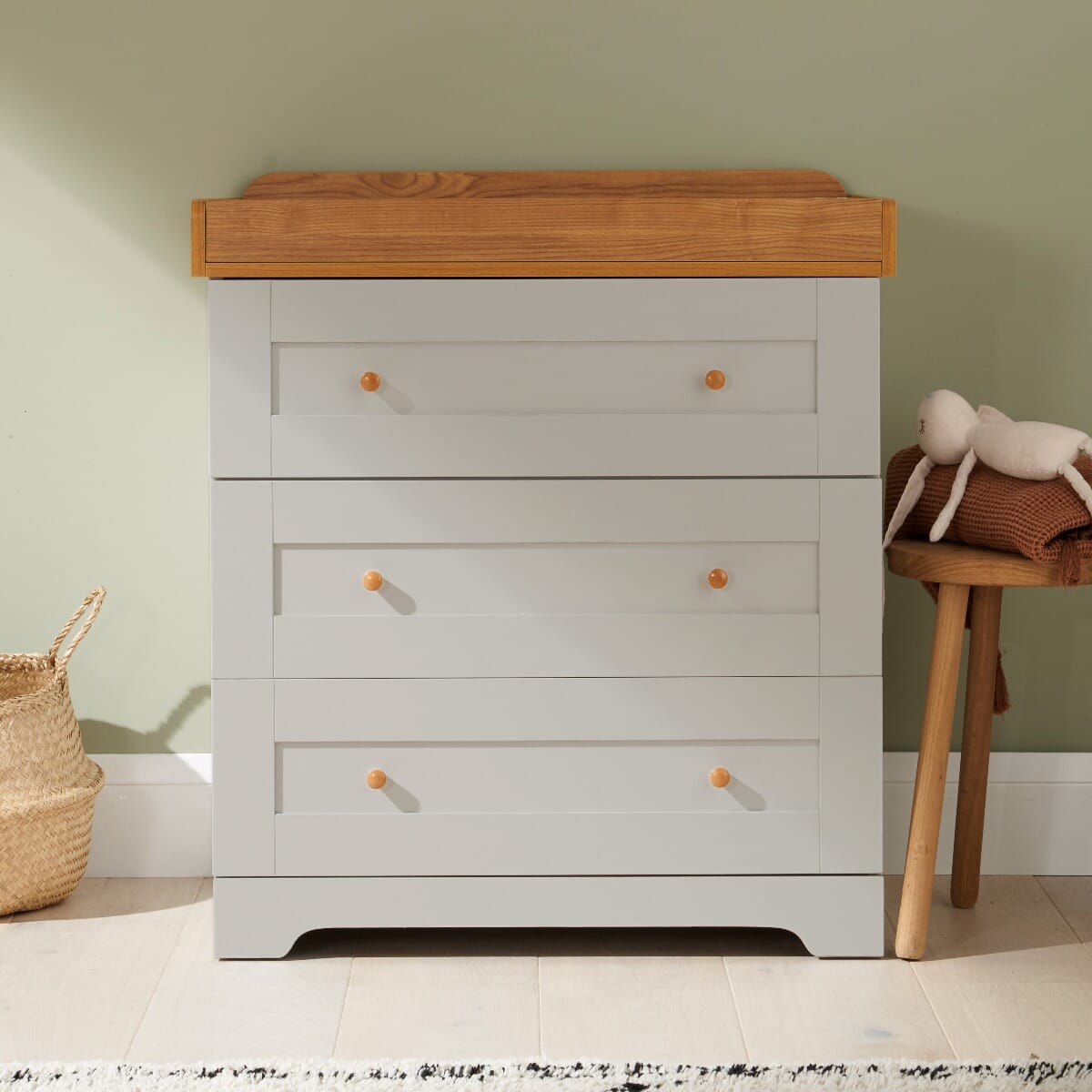 Rio chest changer in dove grey with oak top shown in nursery setting, offering three spacious drawers and warm two-tone finish