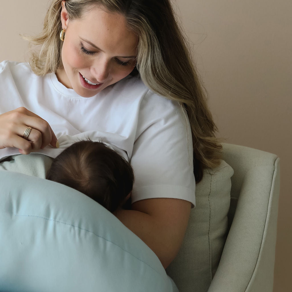 Mother breastfeeding using bluebell SMO nursing pillow, offering support and comfort during feeds