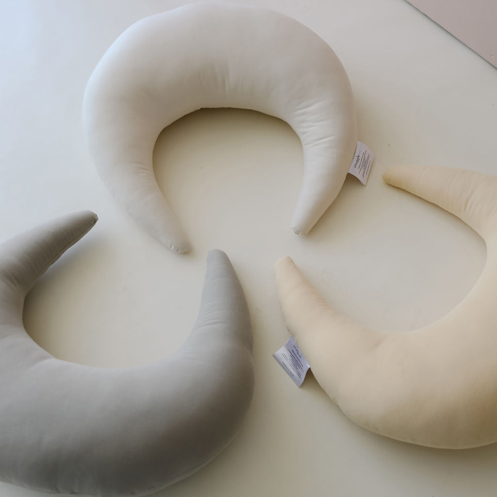 Three SMO nursing pillows in soft neutral colours, styled on a clean white surface