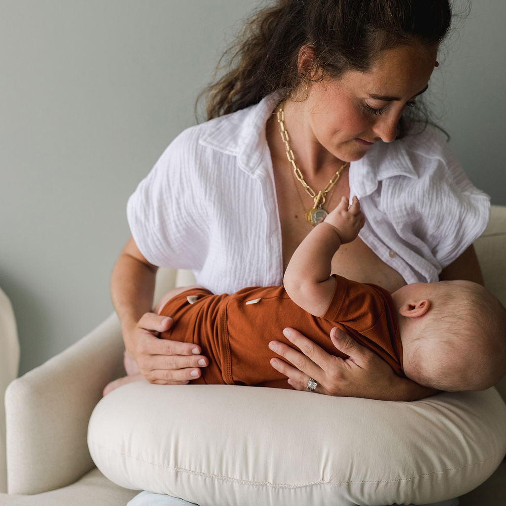 Mother breastfeeds baby using SMO nursing pillow in natural