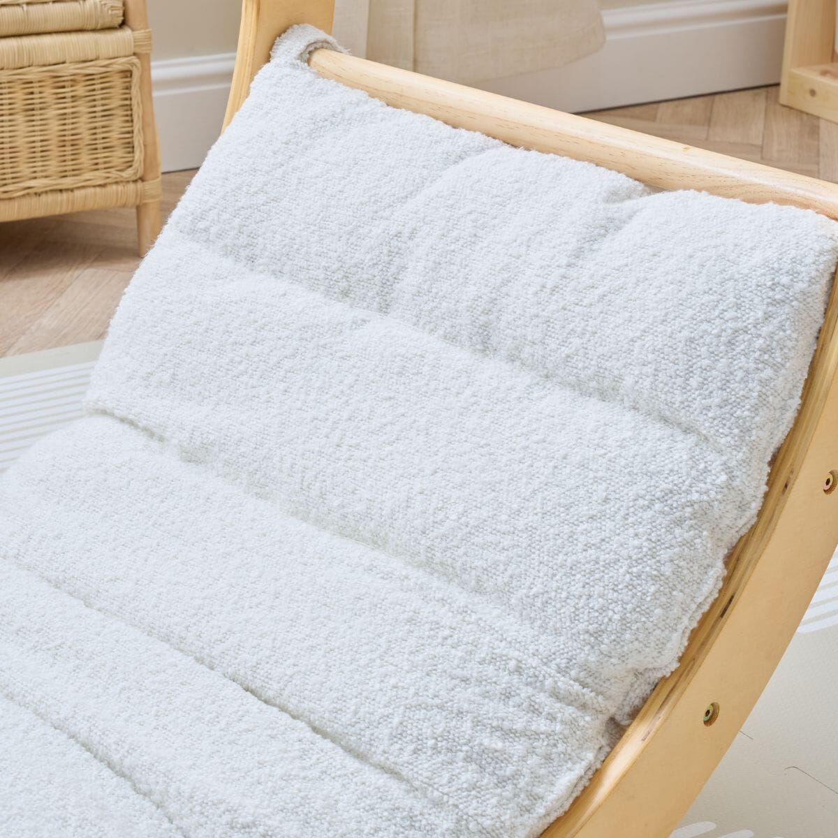 Close-up of the Scala Montessori Pikler rocking frame cushion in boucle natural, showing textured padding and stitched channels