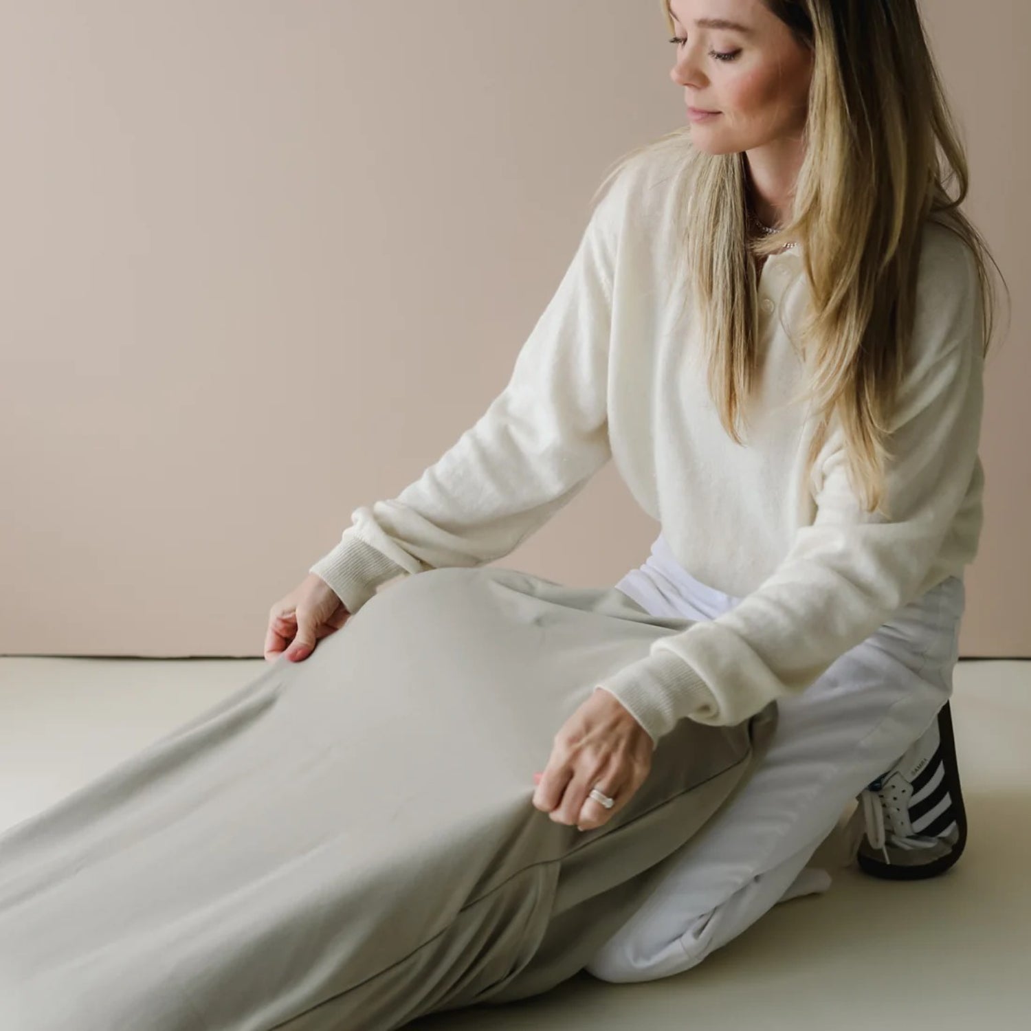 Close-up of Snuggle Me lounger cover in birch, with parent fitting the soft, stretchable fabric over the baby lounger