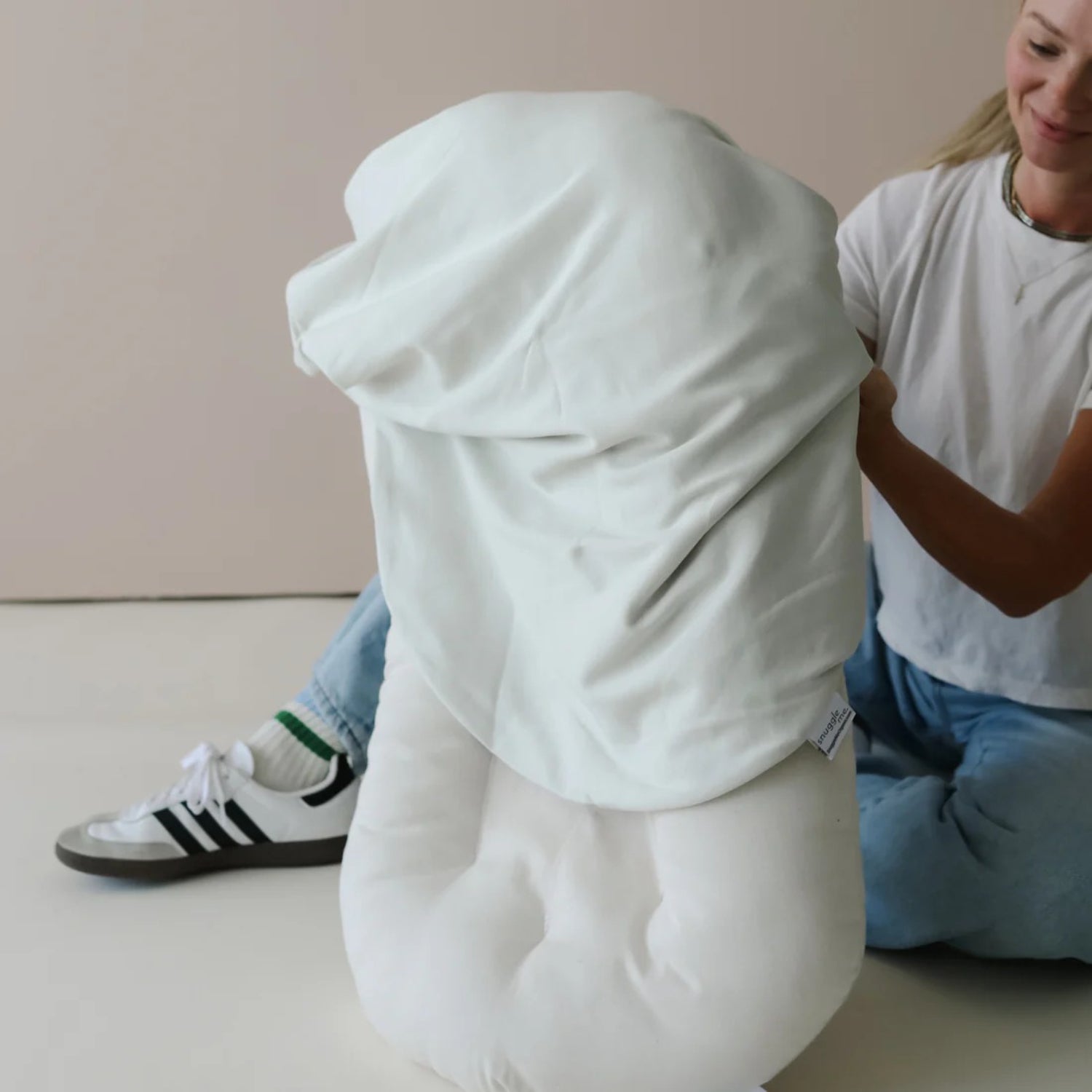 Snuggle me lounger cover sage being applied β stretchy cotton offers a snug fit to keep baby secure and supported.