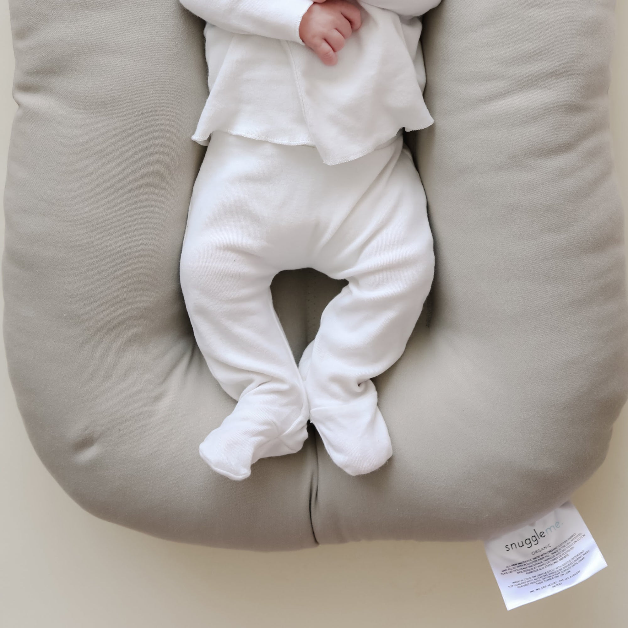 Close-up of baby lying on the snuggle me newborn baby lounger in Birch, showing contoured design and soft natural cotton fabric