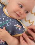 Smiling baby wearing Our Planet baby sleep bag in bamboo cotton, showing adjustable shoulder poppers and playful sea life print.