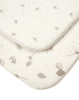 Detailed close-up of Cocoon bedside crib sheets, showing woodland animal and dandelion prints on soft organic cotton