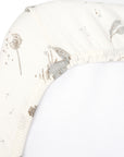 Close-up of Cocoon cot bed fitted sheet corner with elasticated edge, showing soft organic cotton fabric and delicate woodland print detail