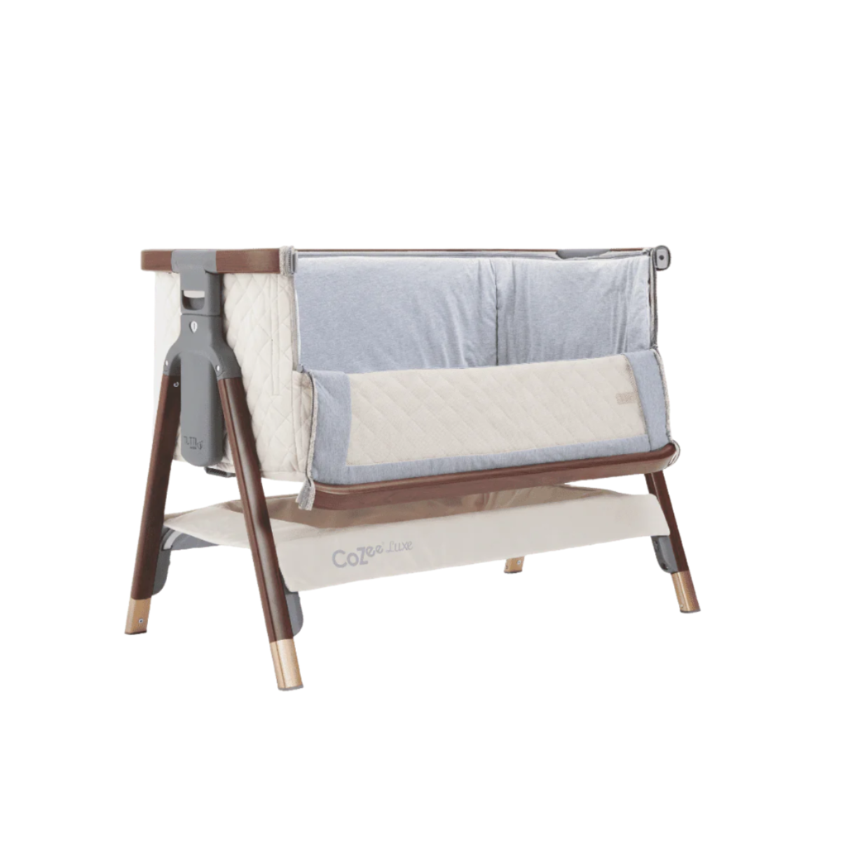 Angled view of the CoZee Luxe bedside crib in walnut and cream with side panel unzipped for safe bedside co-sleeping access