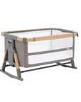 Cutout view of the CoZee XL in oak and charcoal shown in bassinet mode with rocking bars, breathable mesh sides, and grey upholstery