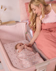 mum touching baby as she lies in the cozee zen in blush
