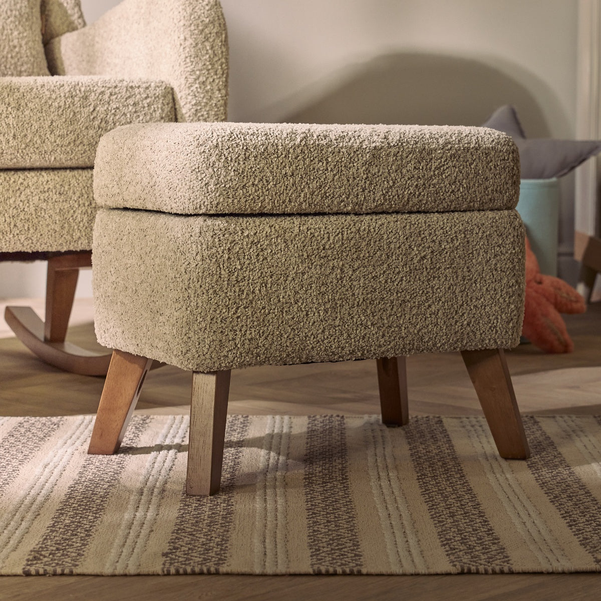 Room view of the Harper Wingback footstool in teddy mushroom, styled in a nursery with rug and accessories, complementing the matching chair.