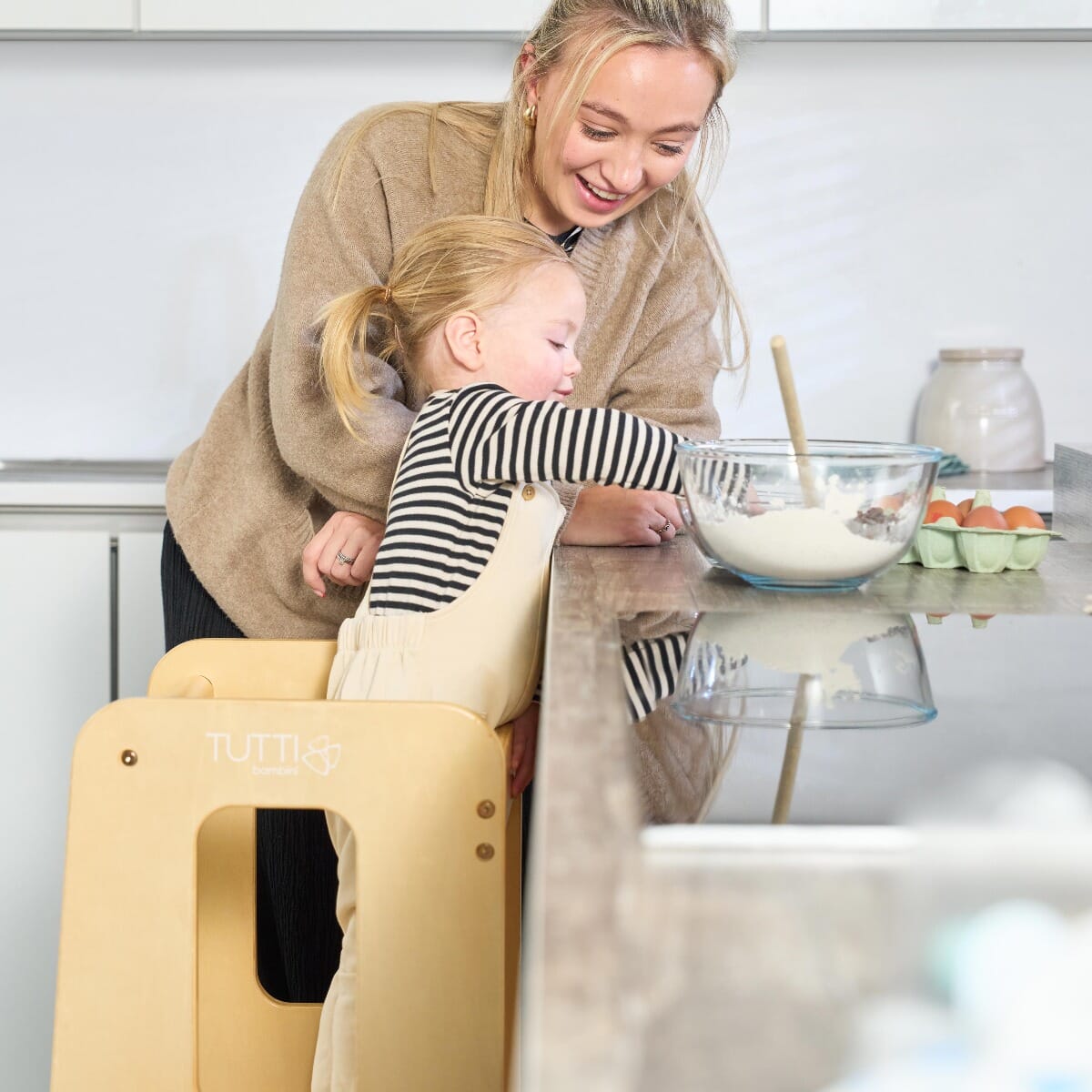 Close-up of mum and toddler at the kitchen counter with the Helping Hands Montessori learning tower in natural finish, encouraging hands-on learning.