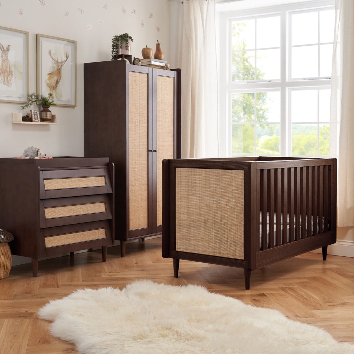 Japandi 3-piece nursery set in warm walnut finish, featuring a cot bed, rattan-panelled wardrobe, and matching chest changer in a styled nursery room, blending natural textures with functional design.