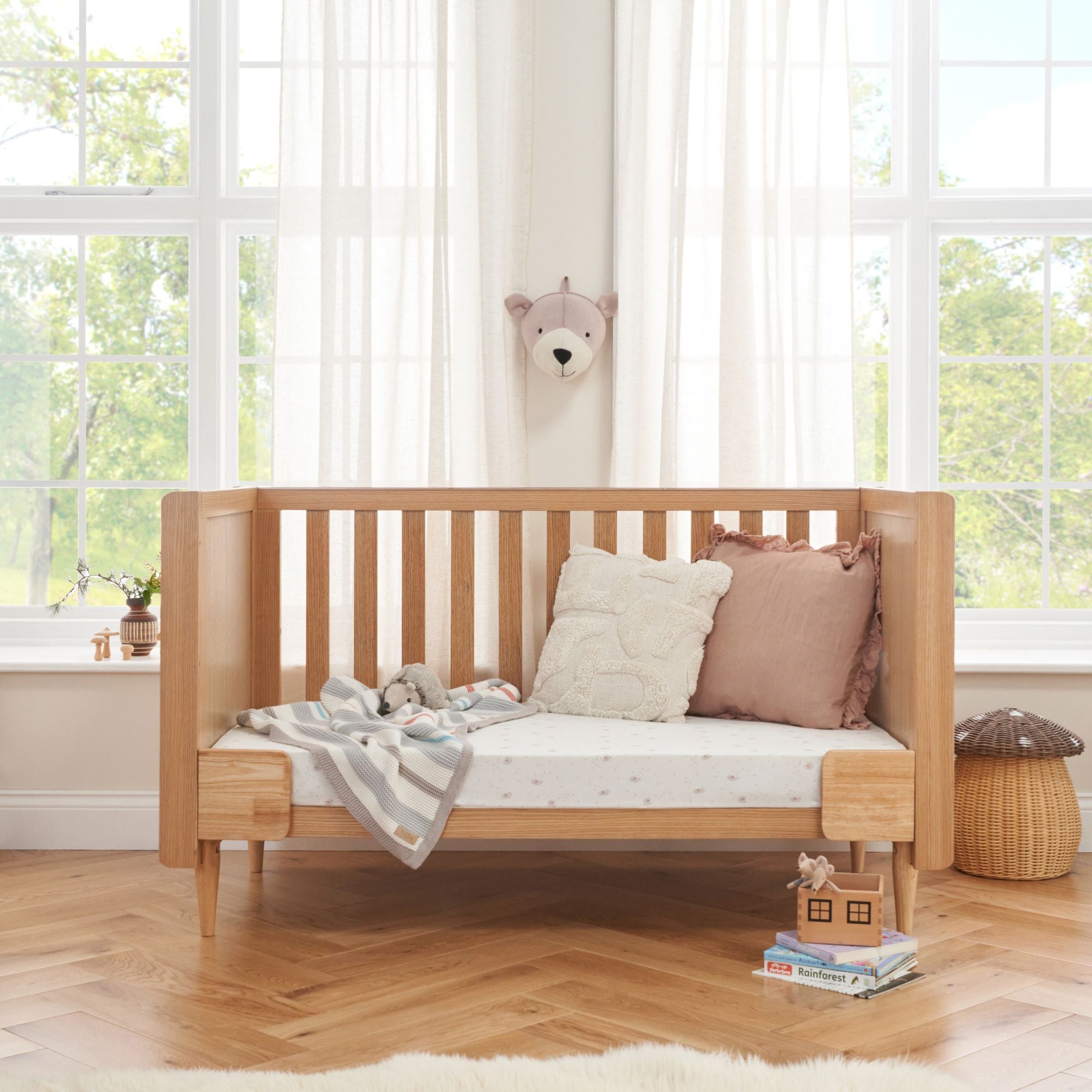 Japandi cot bed in light oak shown in sofa mode for extended use beyond the baby years