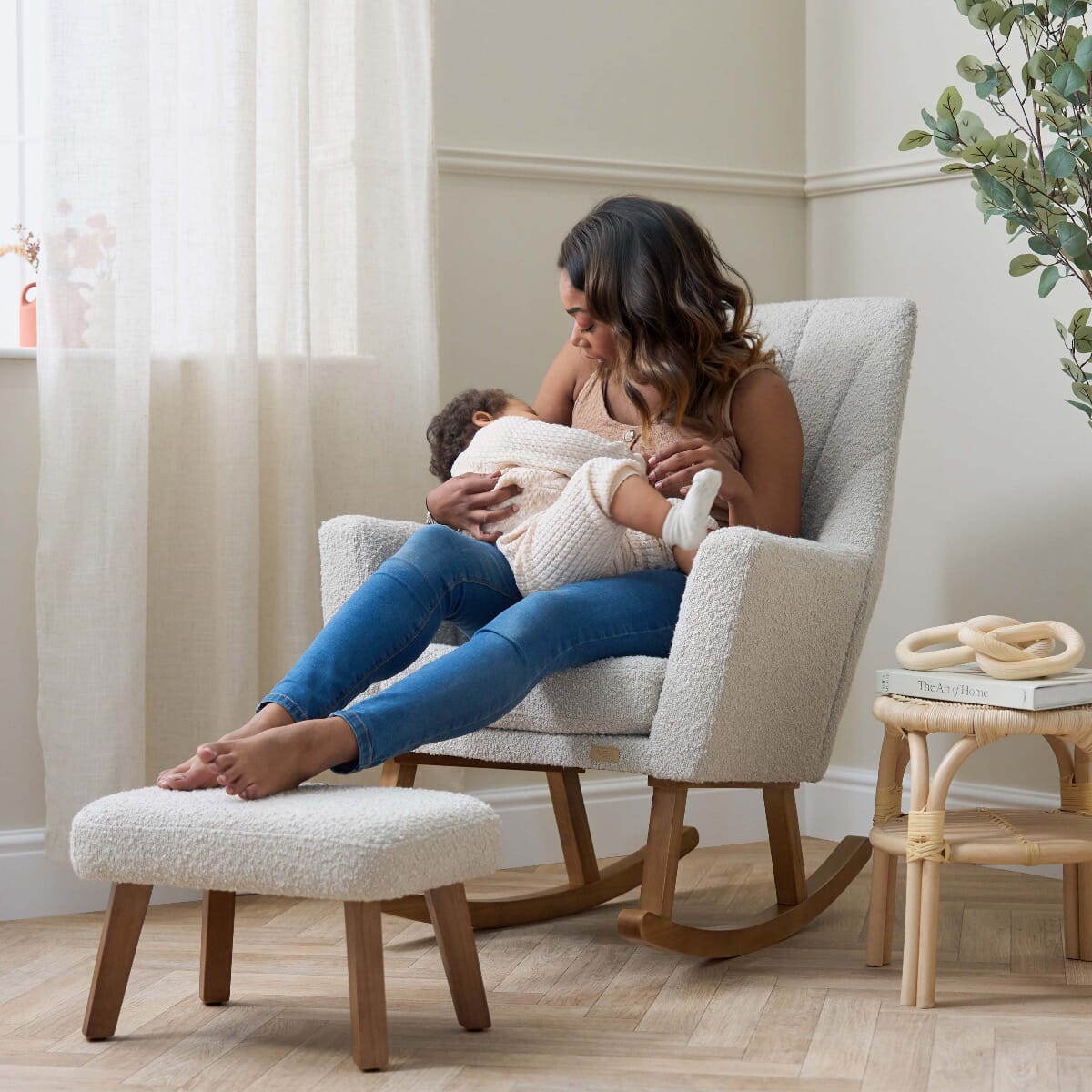 Mum with baby sleeping in the Jonah Luxe rocking chair and footstool in boucle mushroom, showcasing comfort, bonding, and soothing support