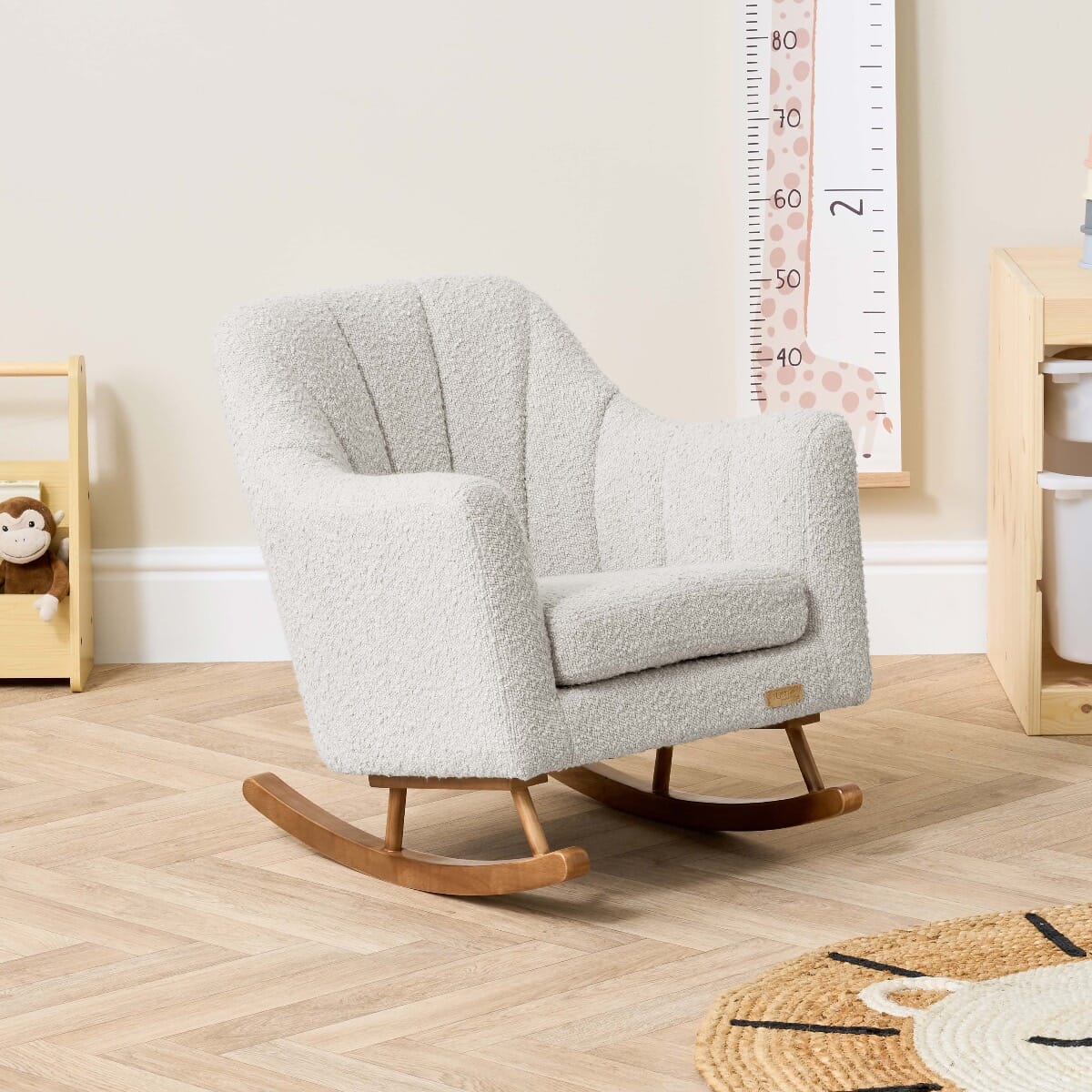 Angled nursery view of the Jonah Mini Me chair in boucle mushroom with soft curves, wooden rockers and inviting texture