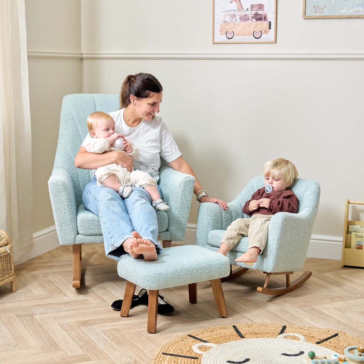 Mum and two children sitting on the Jonah rocking chair and mini rocking chair in Ocean Stone, showing the coordinating boucle fabric set