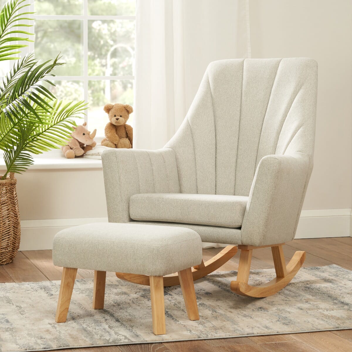 Lifestyle image of the Jonah rocking chair and footstool in Pebble placed in a nursery setting with natural light, plush toys, and wooden flooring.