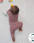 Baby crawls on the mat’s grey reversible side, featuring soft contour lines and cushioned support for comfortable tummy-time play