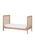 Side view of the Malmo cot bed in toddler bed mode with slatted ends and oak finish, ideal for children aged 2 to 5 years