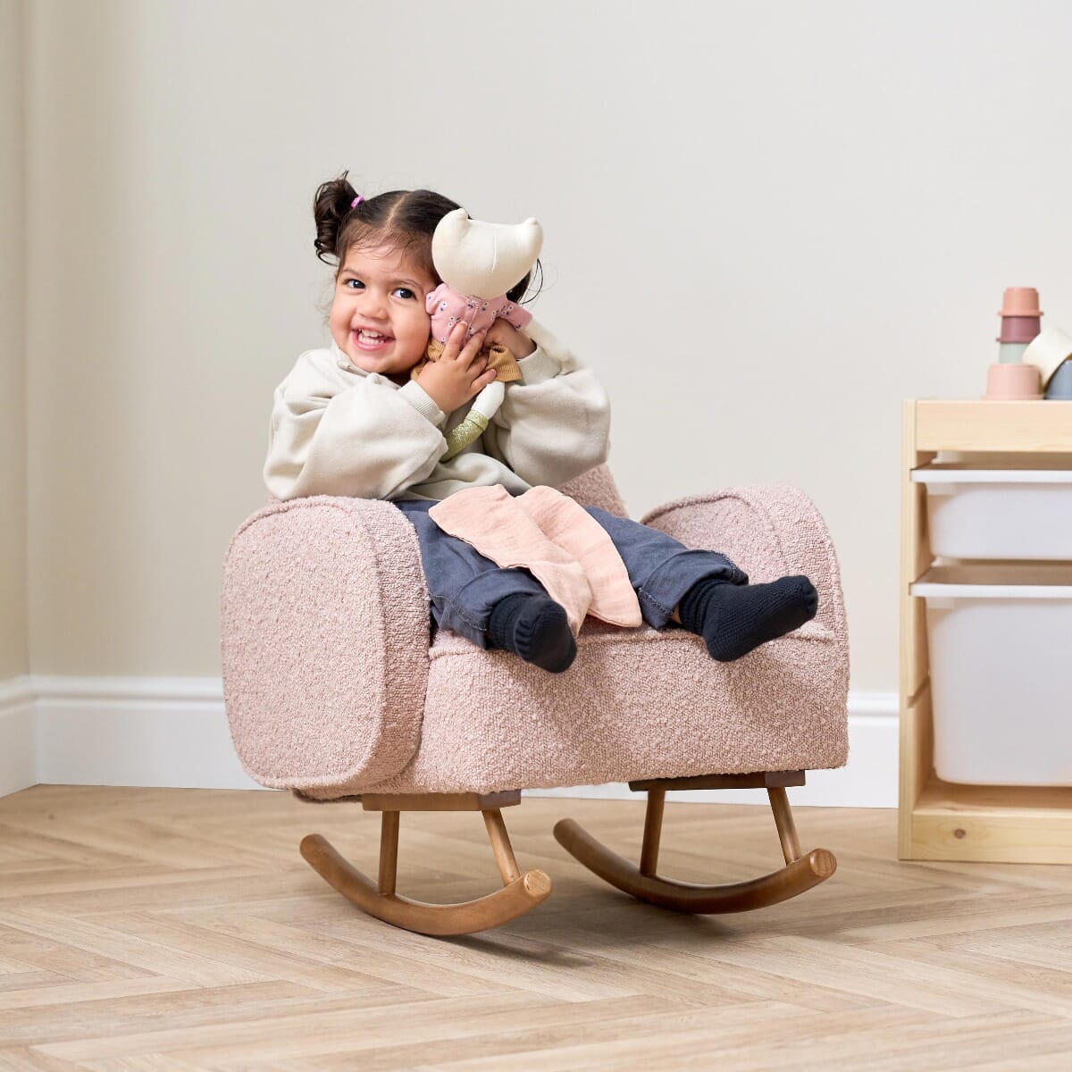 Lifestyle view of child using Micah Mini Me Rocking Chair in boucle blush with ergonomic design for playful comfort.